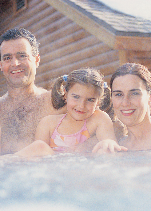 Family in the outdoor hot tub at Harman's Log Cabins in West Virginia.