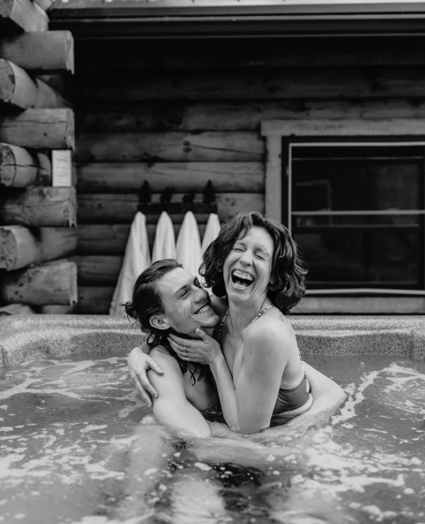 Couple in the private outdoor hot tub at Harman's Log Cabins West Virginia.
